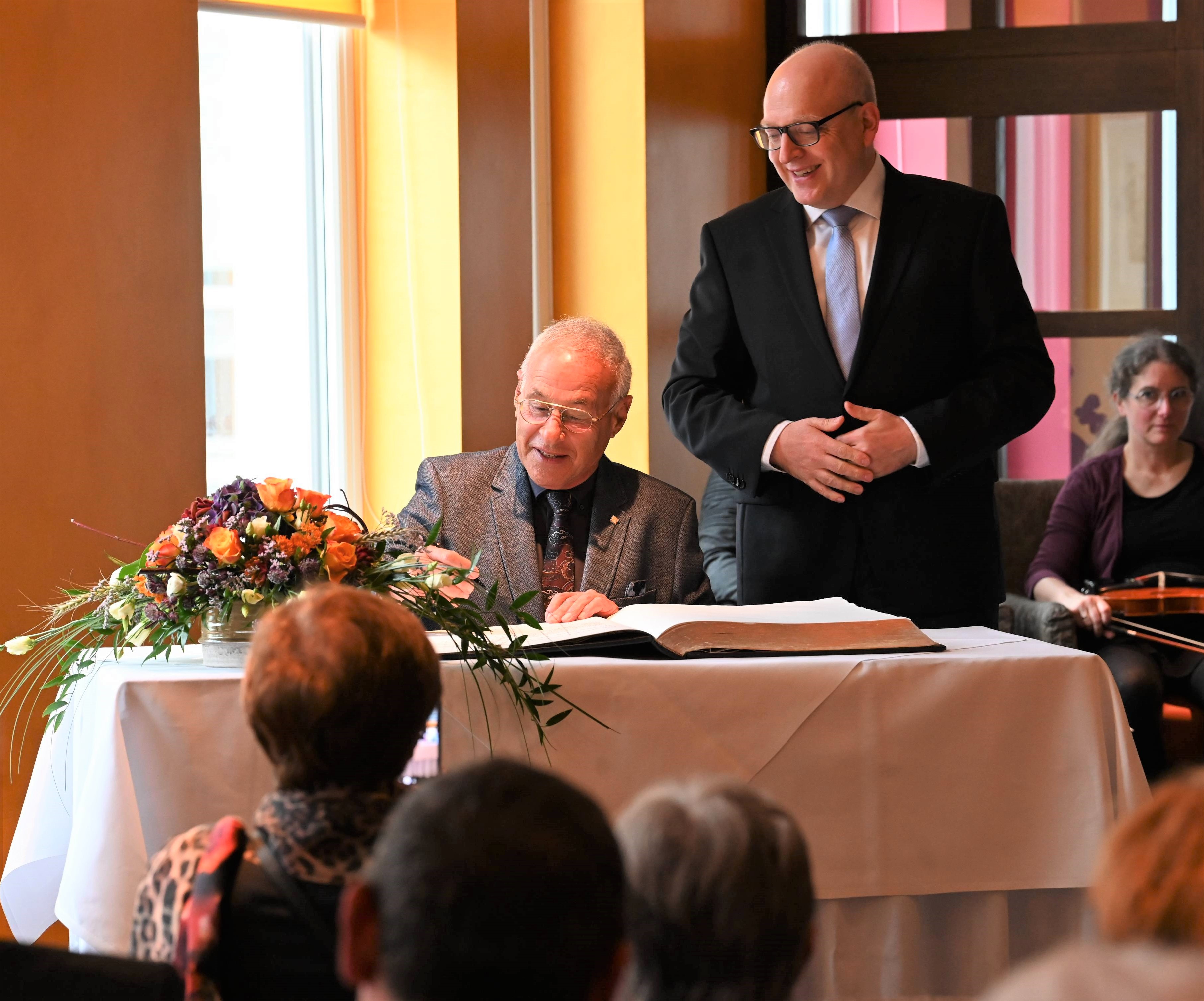 Prof. Dr. Rafael Wertheim (links) trägt sich im Beisein von Oberbürgermeister Sven Schulze in das Goldene Buch der Stadt Chemnitz ein.