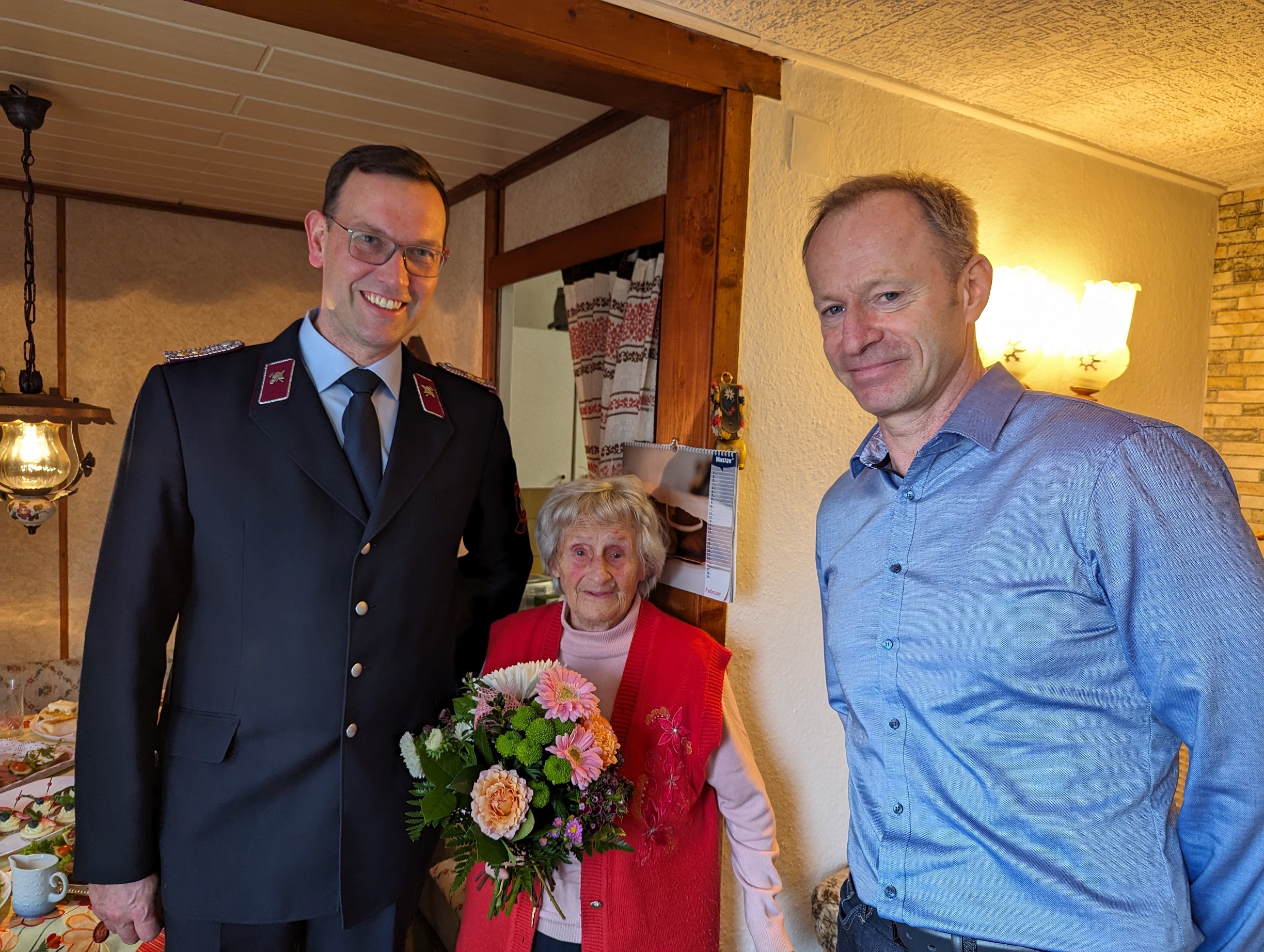 Bürgermeister Knut Kunze (re) und Lars Ehlert, Wehrleiter der FF Euba, gratulieren Ursula Enderlein zum 100. Geburtstag.